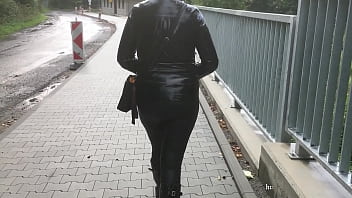 Wife walk in rubber boots, leather leggings and PVC raincoat